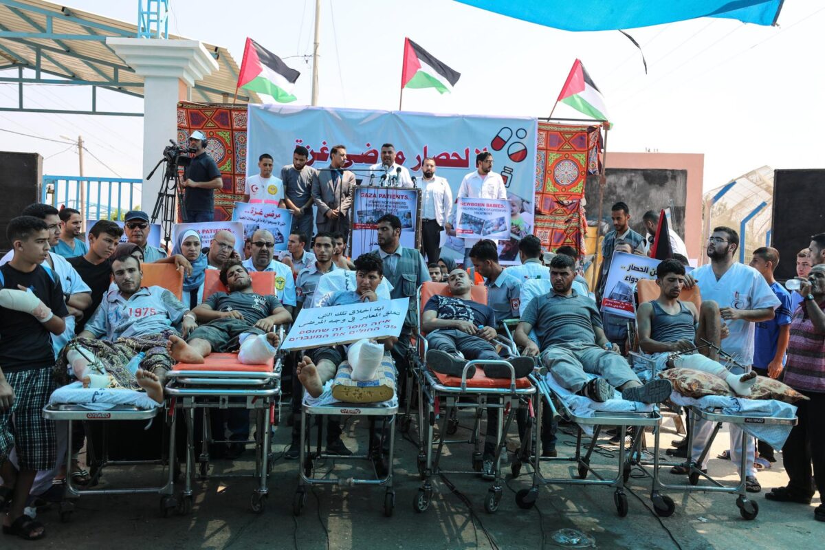 Equipes de primeiro-socorros e pacientes em macas participam de um protesto contra os impedimentos de saúde causados pelo bloqueio de Israel a Gaza, que já dura mais de dez anos, no travessia de Beit Hanoun, Cidade de Gaza, 17 de julho de 2018 [Mustafa Hassona/Agência Anadolu]