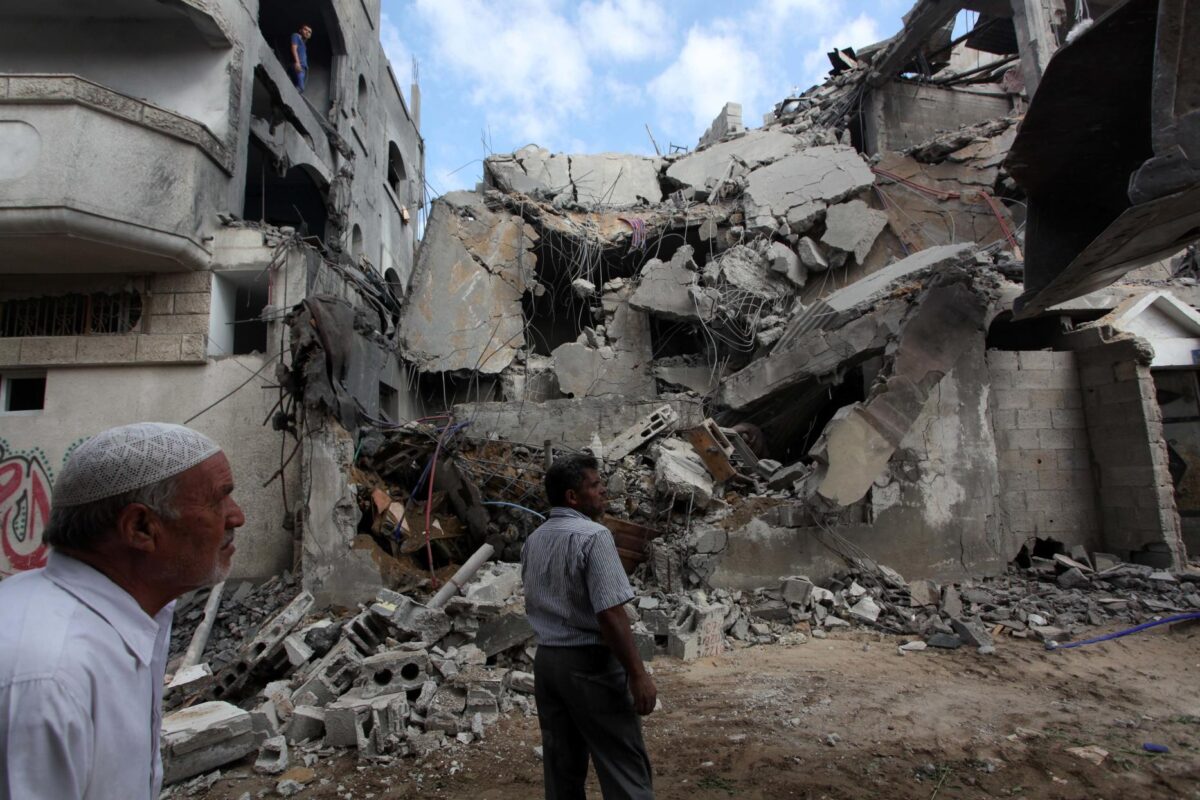  Palestinos inspecionam os escombros de sua casa após ser atingida por ataques aéreos israelenses na cidade de Gaza, em 9 de agosto de 2014 [Ashraf Amra/Apaimages]