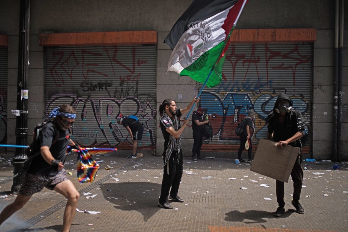 Manifestantes se reúnem para marchar no sexto dia de protestos contra aumento da tarifa do transporte público em Santiago do Chile. Em 23 de outubro de 2019 [Cristobal Venegas / Agência Anadolu] 