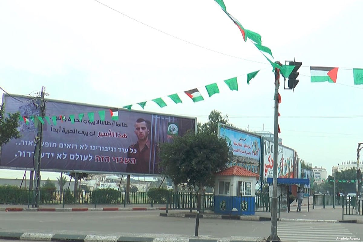 Localizado no entroncamento de Al-Saraya, em Gaza, um cartaz mostra Oren Shaul, um soldado israelense, com barras de prisão ao redor dele, em 29 de dezembro de 2017 [Agência Anadolu] 