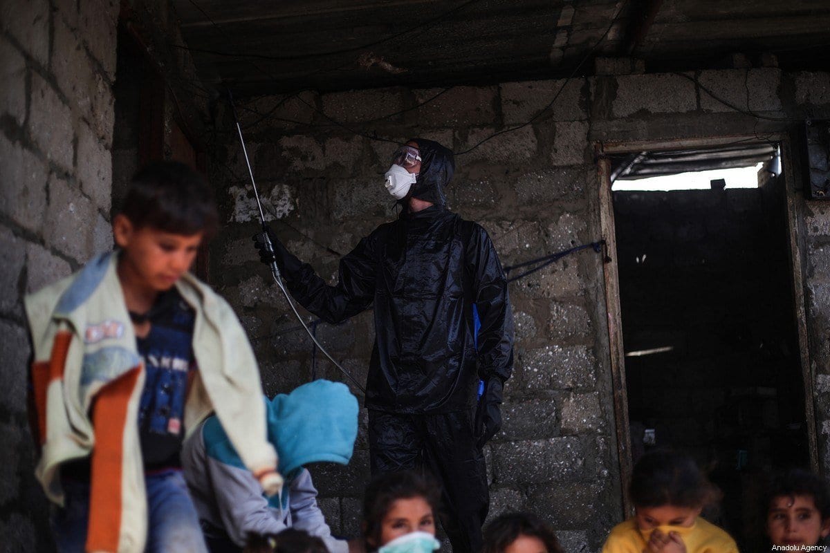 Um grupo de jovens voluntários realiza trabalhos de desinfecção durante a pandemia de coronavírus em Gaza. Em 29 de março de 2020 [Mustafa Hassona / Agência Anadolu] 