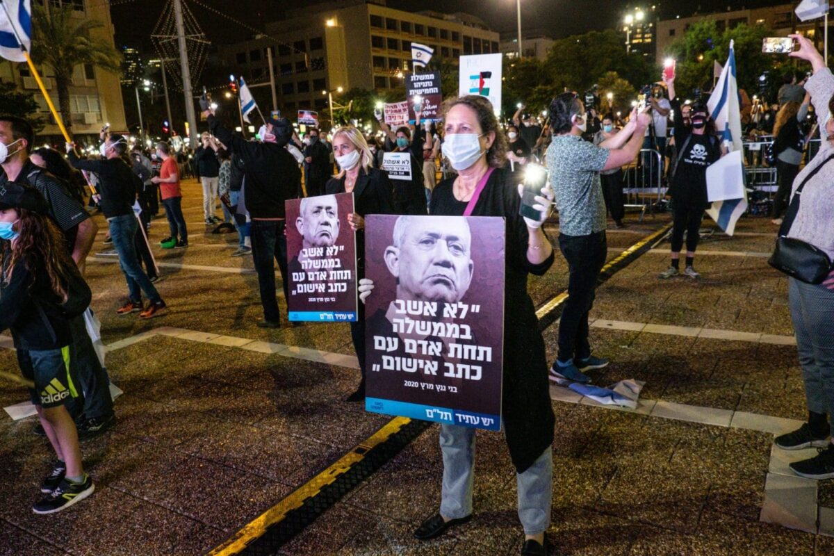 Israelenses usando máscaras protetoras e mantendo distância social se reúnem para protestar contra o primeiro-ministro Benjamin Netanyahu na Praça Rabin, em Tel Aviv, em 19 de abril de 2020 [Nir Keidar / Agência Anadolu] 