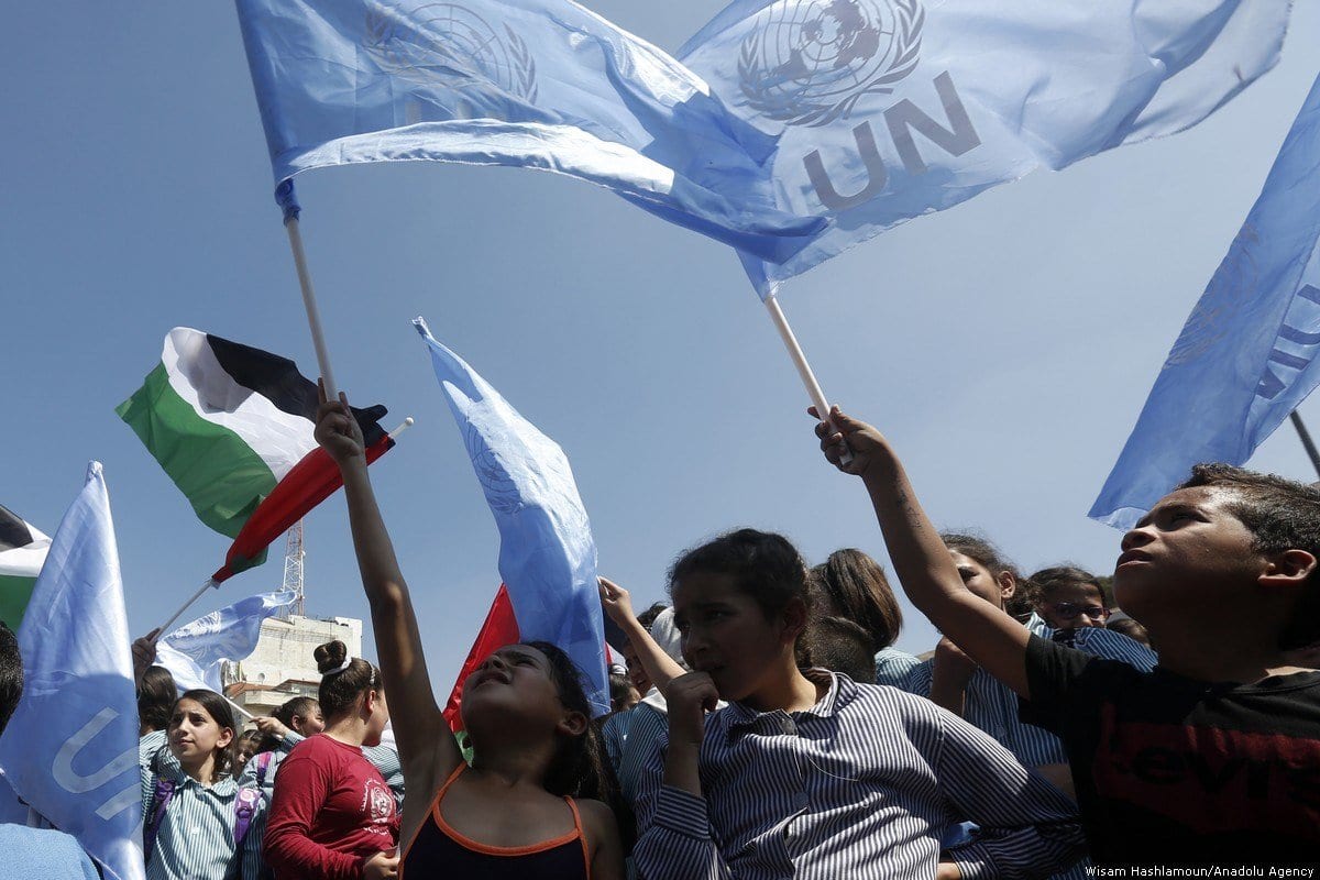  Refugiados palestinos exibem bandeiras durante protesto contra cortes de recursos e redução dos trabalhos da Agência das Nações Unidas de Assistência aos Refugiados da Palestina (UNRWA), em Belém, Cisjordânia ocupada, 26 de setembro de 2018 [Wisam Hashlamoun/Agência Anadolu]