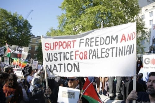 Manifestantes pró-Palestina exibem cartazes em apoio à “liberdade e justiça para a nação palestina”, durante protesto contra a repressão israelense nos territórios ocupados, em Londres, Reino Unido, 15 de maio de 2018 [Yunus Dalgic/Agência Anadolu]