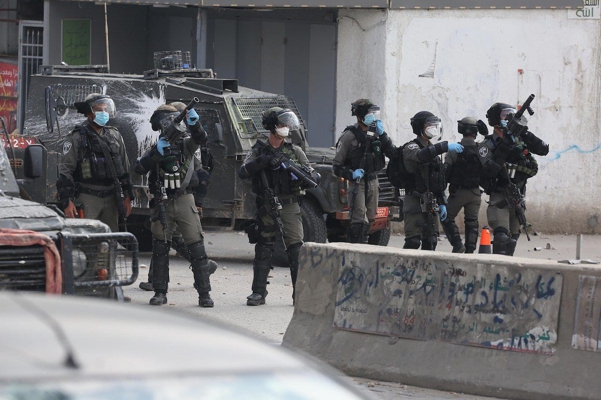 Soldados israelenses usam gás lacrimogêneo para dispersar palestinos que reagem a uma invasão no campo de refugiados de Kalandia, em Ramallah, Cisjordânia ocupada, 14 de abril de 2020 [Issam Rimawi/Agência Anadolu]