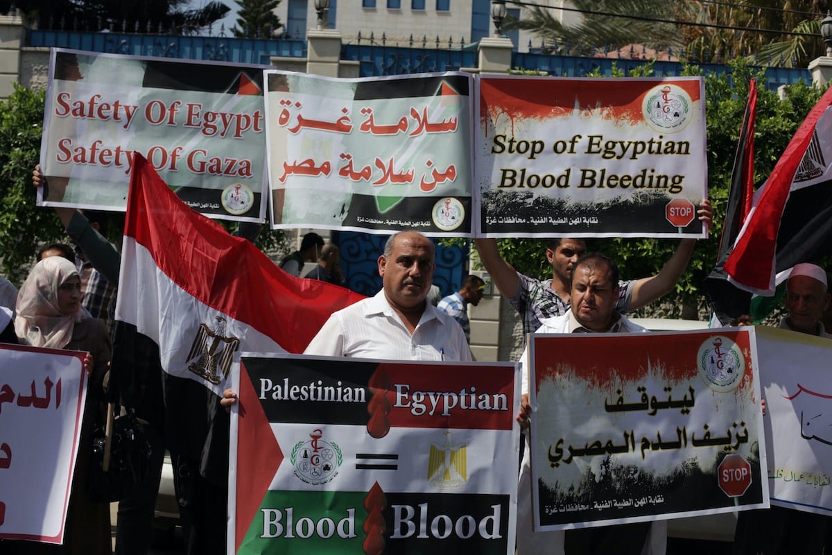 Palestinos protestam com cartazes em apoio ao presidente egípcio então deposto Mohamed Morsi, na Cidade de Gaza, 19 de agosto de 2013 [Ashraf Amra/Apaimages]