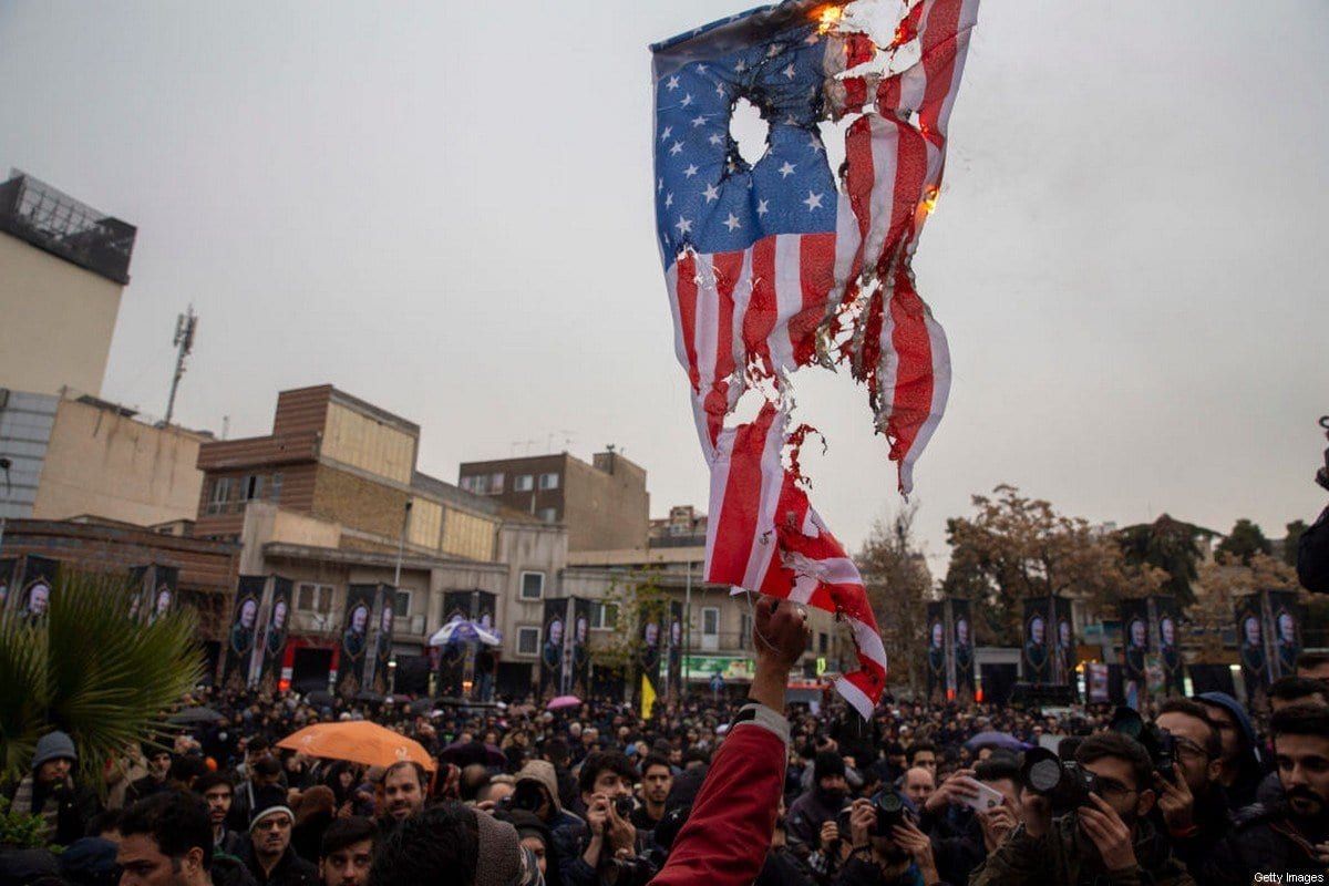 Iranianos queimam bandeiras dos Estados Unidos e Israel durante protesto contra as mortes do comandante iraniano Qasem Soleimani e o chefe paramilitar iraquiano Abu Mahdi al-Muhandis, em Teerã, Irã, 4 de janeiro de 2020 [Majid Saeedi/Getty Images]