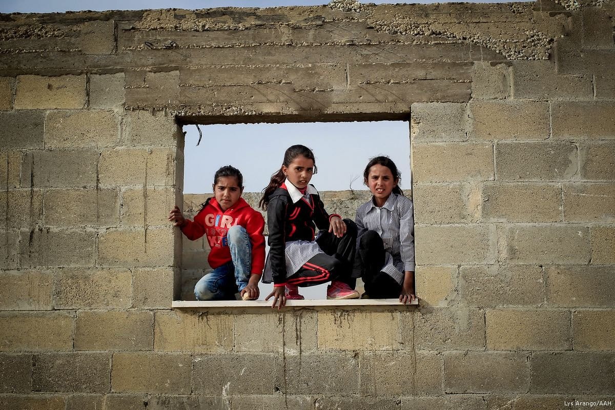 Crianças palestinas posam na frente de uma escola. Crianças da comunidade beduína correm o risco de perder a escola se os tribunais israelenses decidirem por sua demolição. [Lys Arango / AAH]