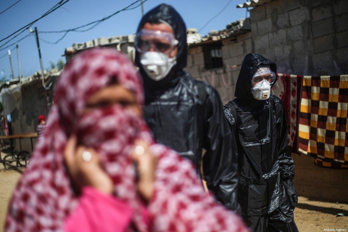 Um grupo de jovens voluntários realiza trabalho de desinfecção durante a pandemia de coronavírus em Gaza em 29 de março de 2020 [Mustafa Hassona/ Anadolu Agência]