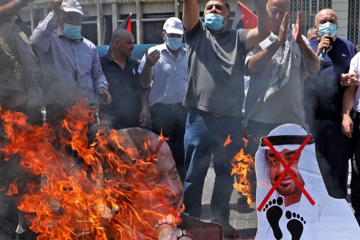 Manifestantes palestinos incendiaram cartazes com os rostos do primeiro-ministro israelense Benjamin Netanyahu e do príncipe herdeiro de Abu Dhabi Sheikh Mohammed bin Zayed al-Nahyan durante uma manifestação em Nablus, na Cisjordânia, ocupada em 14 de agosto de 2020 contra um Acordo mediado pelos EUA entre Israel e os Emirados Árabes Unidos para normalizar as relações. É o terceiro acordo que o estado judeu faz com uma nação árabe, uma mudança histórica que torna o estado do Golfo apenas o terceiro país árabe a estabelecer laços diplomáticos plenos com o estado judeu. A liderança palestina expressou sua "forte rejeição e condenação" do acordo e anunciou que retiraria seu enviado dos Emirados Árabes Unidos.. (Jaafar Ashtiyeh/ AFP)