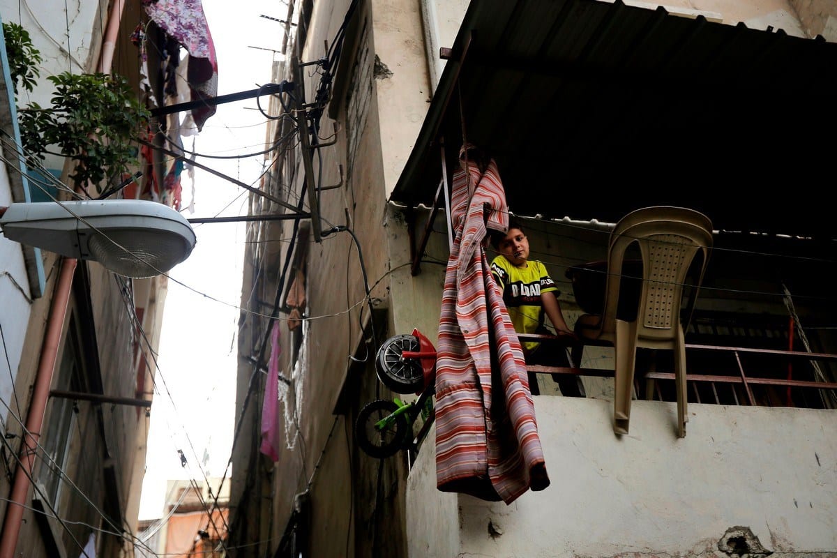 Menino olha de uma varanda em Trípoli, Líbano, 3 de junho de 2020 [Joseph Eid/ AFP / Getty Images]