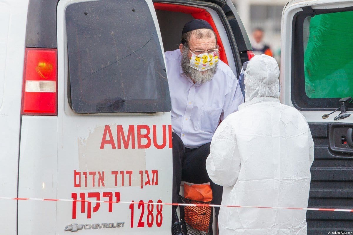 Um oficial de saúde verifica um cidadão na ambulância como uma precaução contra o coronavírus em Tel Aviv em 3 de abril de 2020 [Nir Keidar / Agência Anadolu]
