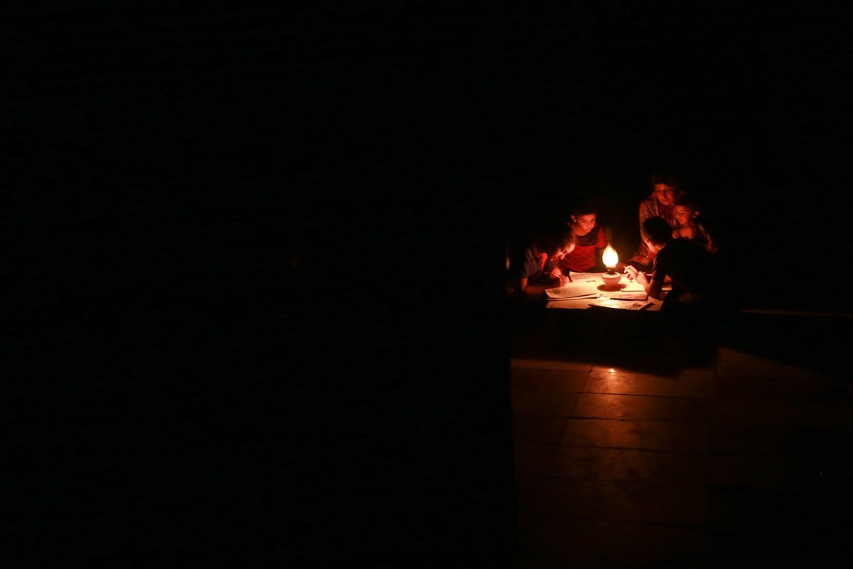 Crianças estudam à luz de velas durante um corte de energia em Khan Yunis, Gaza em 18 de agosto de 2020 [Mustafa Hassona/ Anadolu Agência]