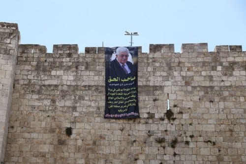 Presidente da Autoridade Palestina Mahmoud Abbas é retratado em um cartaz pendurado nos muros da Cidade Velha de Jerusalém, em 20 de agosto de 2020. Em árabe: ‘O verdadeiro dono é mais forte do que todo o dinheiro. Exortamos o governo de Abu Dhabi nos Emirados Árabes Unidos a retomar a posição árabe e islâmica, revogar este pacto vergonhoso e não tomar parte no chamado acordo do século dos Estados Unidos. As feridas de Jerusalém não serão tratadas com o sal de seu dinheiro’ [Ammar Awad/Twitter]