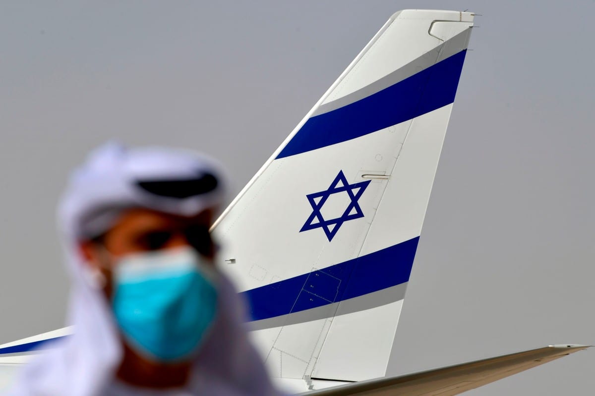 Oficial emiradense ao lado de avião da El Al, após primeiro voo comercial realizado entre Israel e Emirados Árabes Unidos, 31 de agosto de 2020 [Karim Sahib/AFP/Getty Images]