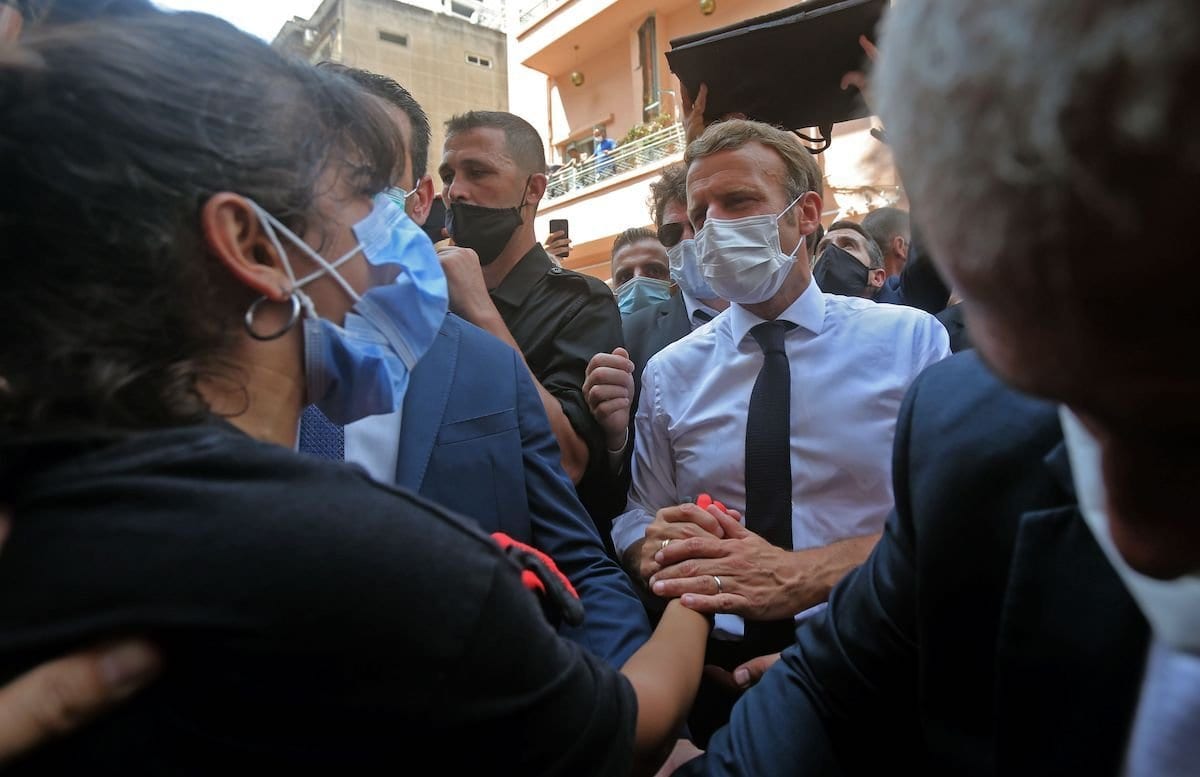 Presidente da França Emmanuel Macron consola uma jovem libanesa durante visita ao bairro de Gemmayzeh, um dos mais atingidos pela explosão, em Beirute, 6 de agosto de 2020 [AFP/Getty Images]