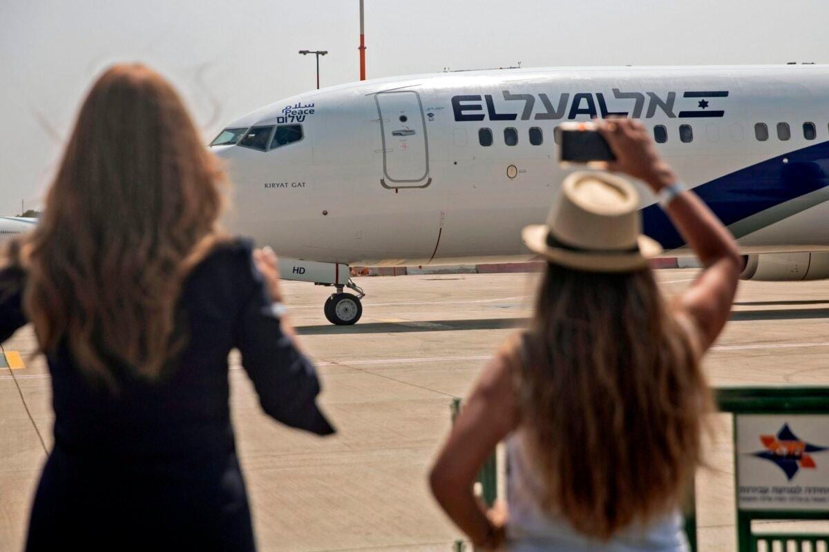 Duas israelenses fotografam o avião que parte para o primeiro vôo direto rumo aos Emirados Árabes [Getty Images]
