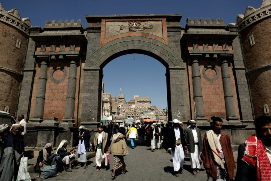 Os iemenitas passam sob o icônico Portão do Iêmen, que leva à cidade velha de Sanaa em 8 de novembro de 2009 [MARWAN NAAMANI / AFP via Getty Images]
