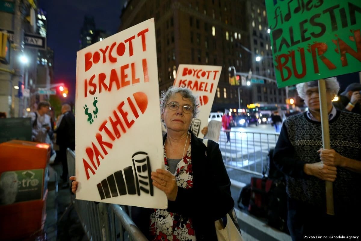 Ativistas de direitos humanos exibem cartazes contra o apartheid israelense e a ocupação na Palestina, em Nova Iorque, Estados Unidos, 25 de outubro de 2017 [Volkan Furuncu/Agência Anadolu]
