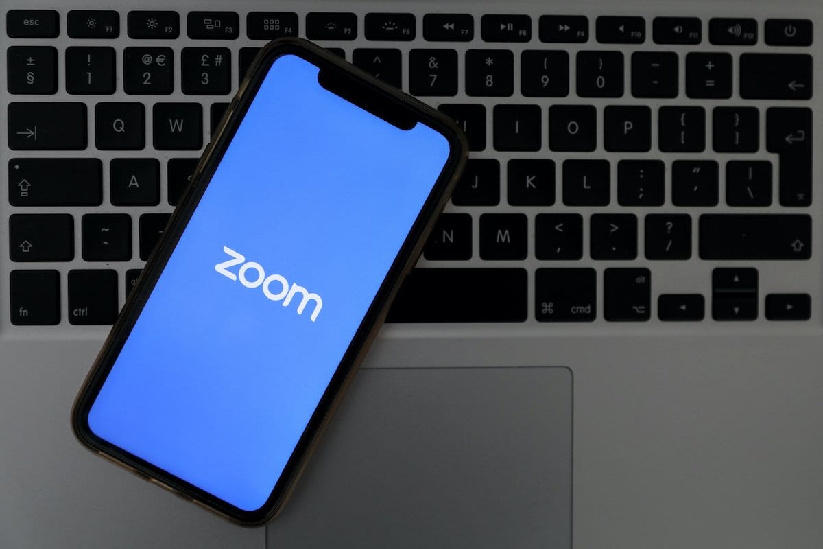 Logo do Zoom, empresa de videoconferência para celular e desktop, visto com fundo escrito 'covid-19', em Ancara, Turquia, 30 de março de 2020 [Hakan Nural/Agência Anadolu]