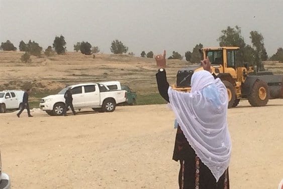 Mulher da aldeia beduína gesticula contra os tratores israelense, na aldeia de Al-Araqib, em 4 de abril de 2019 [Ma’an News]