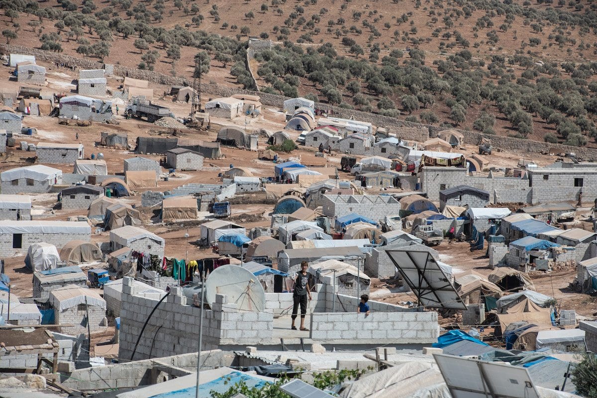 Menino sírio deslocado na laje de sua casa, na aldeia de Atmeh, que abriga quase um milhão de refugiados sírios, perto da fronteira entre Síria e Turquia, na província de Idlib, 17 de setembro de 2019 [Burak kara/Getty Images]