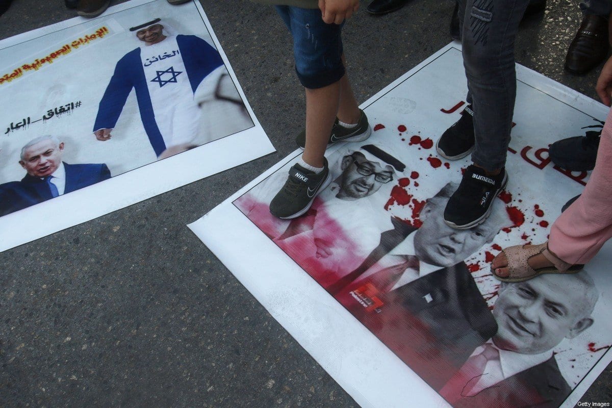Refugiados palestinos pisam nas fotos do príncipe herdeiro de Abu Dhabi, xeque Mohammed bin Zayed Al Nahyan, do Presidente dos Estados Unidos Donald Trump, e do Primeiro-Ministro de Israel Benjamin Netanyahu, durante manifestação contra o acordo entre Emirados e Israel na cidade costeira de Tiro, Líbano, 15 de agosto de 2020 [Mahmoud Zayyat/AFP/Getty Images]
