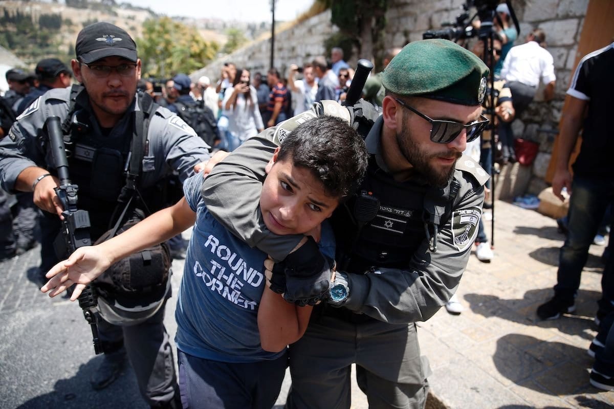 Guardas de fronteira de Israel detêm um menino palestino durante protesto em frente ao chamado Portão do Leão, principal entrada ao complexo de Al-Aqsa, contra medidas de segurança abusivas recém-implementadas, como câmeras e detectores de metal, na Cidade Velha de Jerusalém, 17 de julho de 2017 [Ahmad Gharabli/AFP/Getty Images]