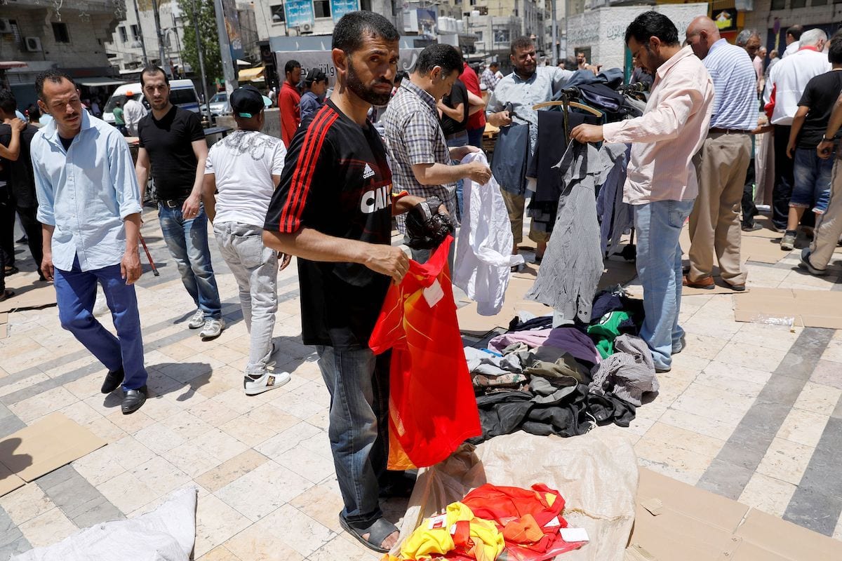 Jordanianos compram roupas de segunda mão em um mercado ao ar livre no centro de Amã em 8 de junho de 2018. [Ahmad Gharabli/ AFP via Getty Images]