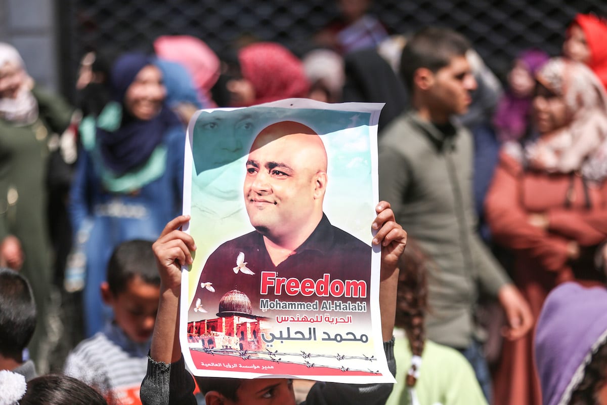 Manifestantes palestinos exibem cartazes com a imagem de Mohammed Al-Halabi, em Gaza, 28 de março de 2017 [Mustafa Hassona/Agência Anadolu]
