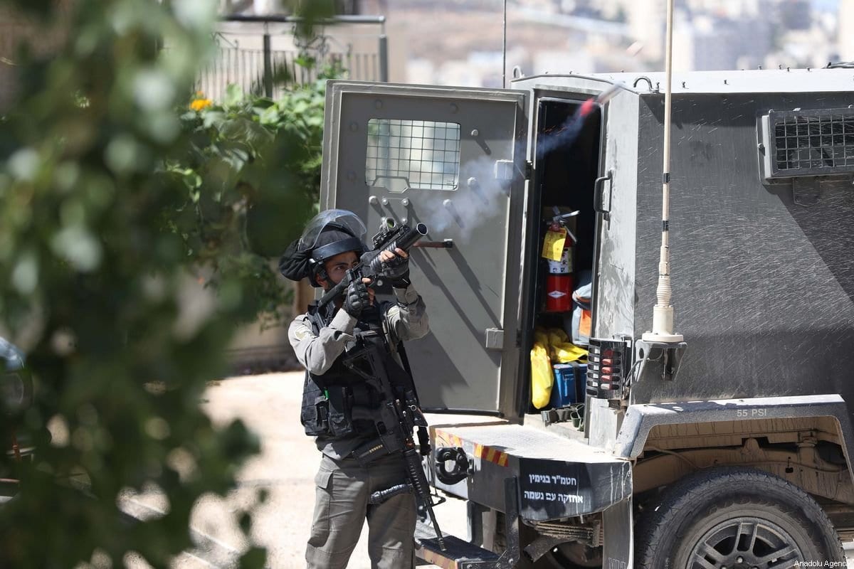 Soldado israelense dispara gás lacrimogêneo contra palestinos, na Cisjordãnia ocupada, 29 de setembro de 2019 [Issam Rimawi/Agência Anadolu]
