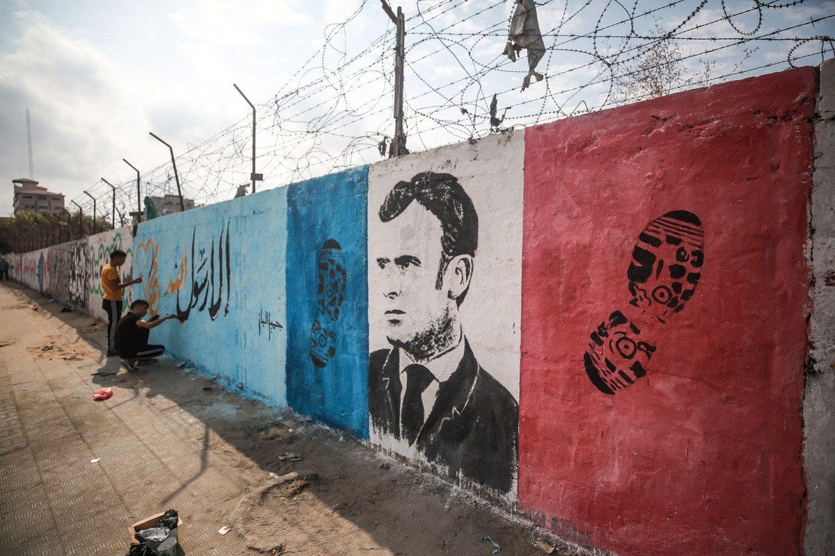 Pintura em muro retrata o presidente francês Emmanuel Macron ao lado de pisadas como uma reação às suas declarações anti-islã, no acampamento Nuseirat na cidade de Gaza, Gaza em 28 de outubro de 2020 [Mustafa Hassona / Agência Anadolu]