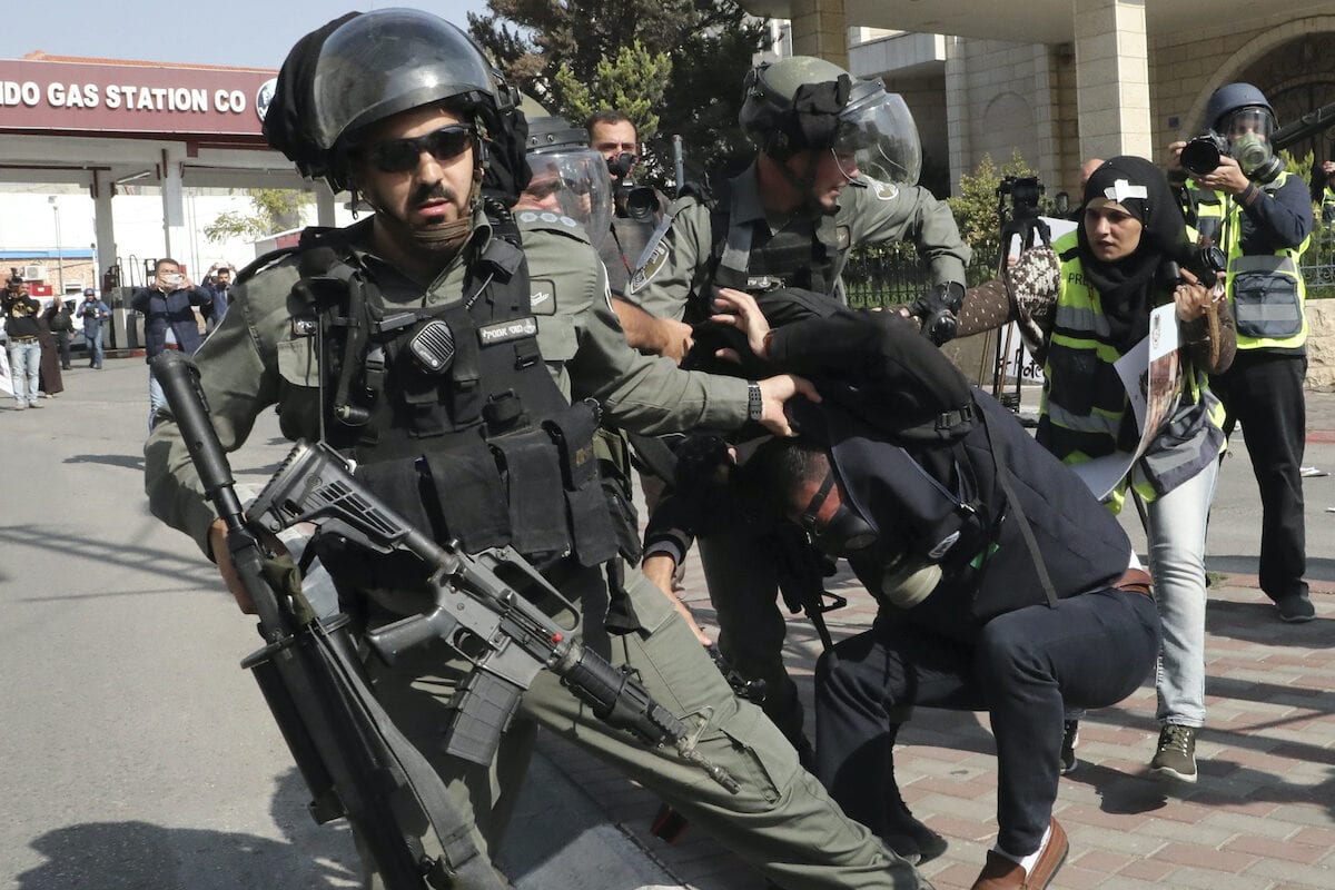 
Guardas de fronteira israelenses detêm um jornalista palestino durante uma manifestação pela polêmica barreira de separação de Israel em Belém, na Cisjordânia ocupada, em 17 de novembro de 2019 [Hazem Bader/ AFP via Getty Images]
