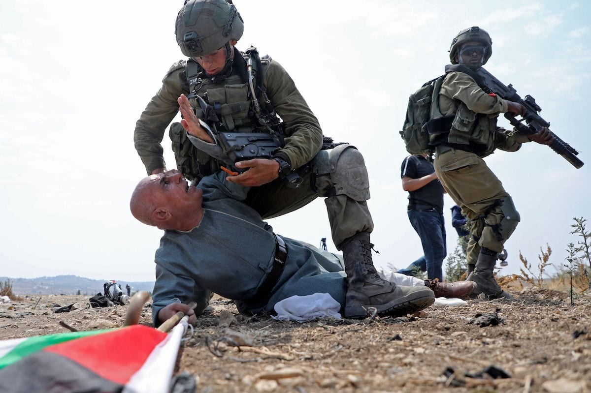 Um soldado israelense detém um palestino na Cisjordânia, em 1 de setembro de 2020 [Jaafar Ashtiyeh/ AFP/ Getty Images]
