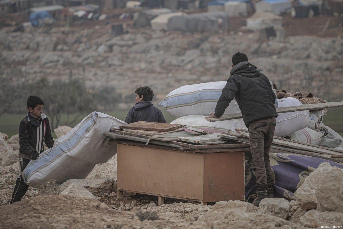 Filhos de famílias sírias vistas em um acampamento em Turmanin na zona rural ocidental de Aleppo, perto da fronteira com a Turquia, em um dia frio de inverno em Idlib, Síria, em 14 de fevereiro de 2020 [Muhammed Said/ Agência Anadolu]
