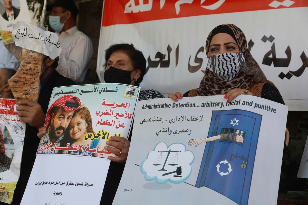 Manifestantes exibem cartazes em apoio aos presos palestinos mantidos nas cadeias israelenses, em Ramallah, Cisjordânia ocupada, 20 de outubro de 2020 [Issam Rimawi/Agência Anadolu]
