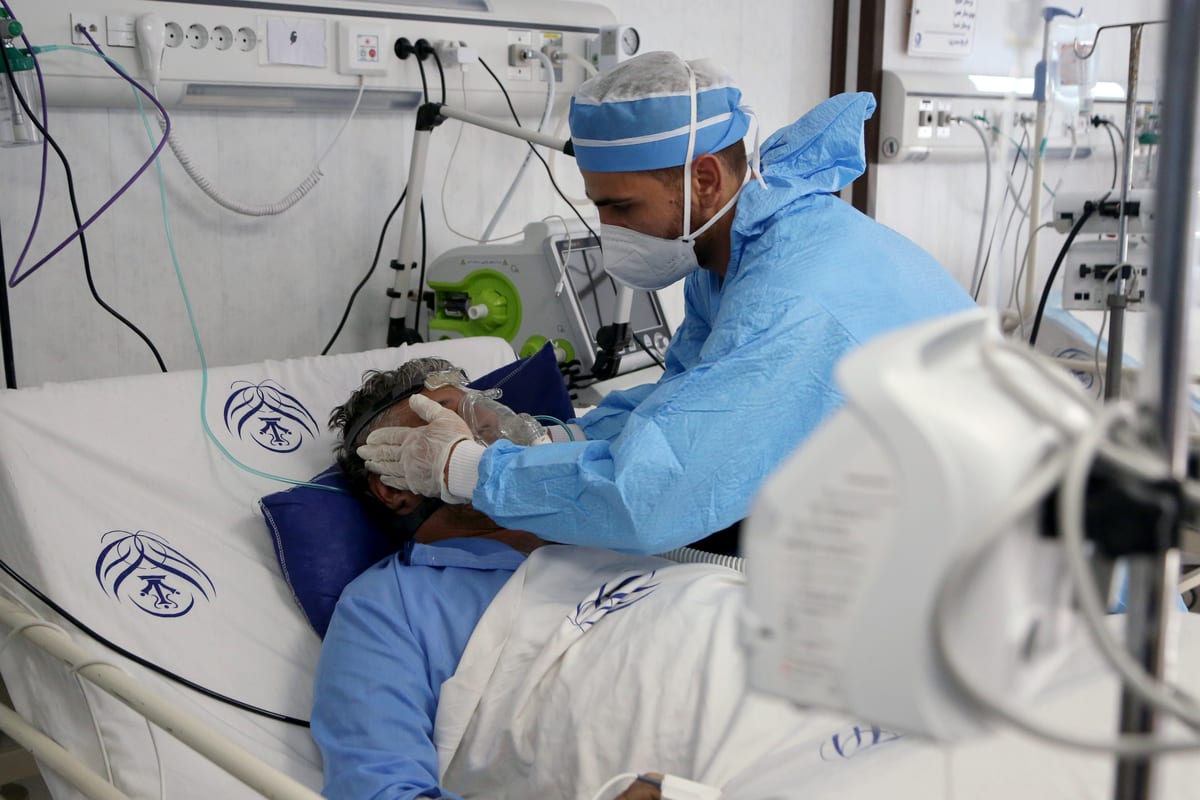 Profissional da saúde, com equipamentos de proteção, checa um paciente com coronavírus (covid-19), em Teerã, Irã, 20 de outubro de 2020 [Fatemeh Bahrami/Agência Anadolu]
