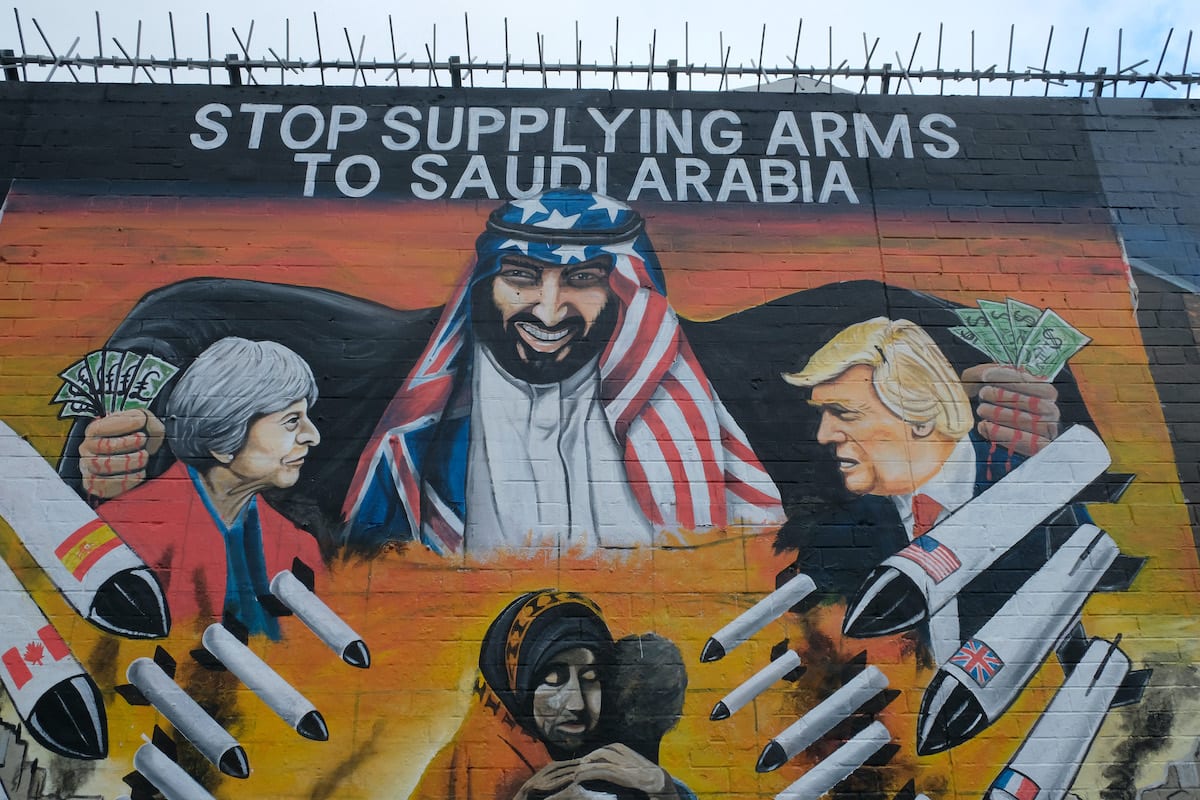 Príncipe MBS da Arábia Saudita retratado em um mural com mãos ensanguentadas cheias de notas de dólares americanos comprando armas e mísseis de Donald Trump e Theresa May, para usar ​​contra o povo iemenita. Em 29 de outubro de 2019 em Belfast, Reino Unido [Kaveh Kazemi / Getty Images]