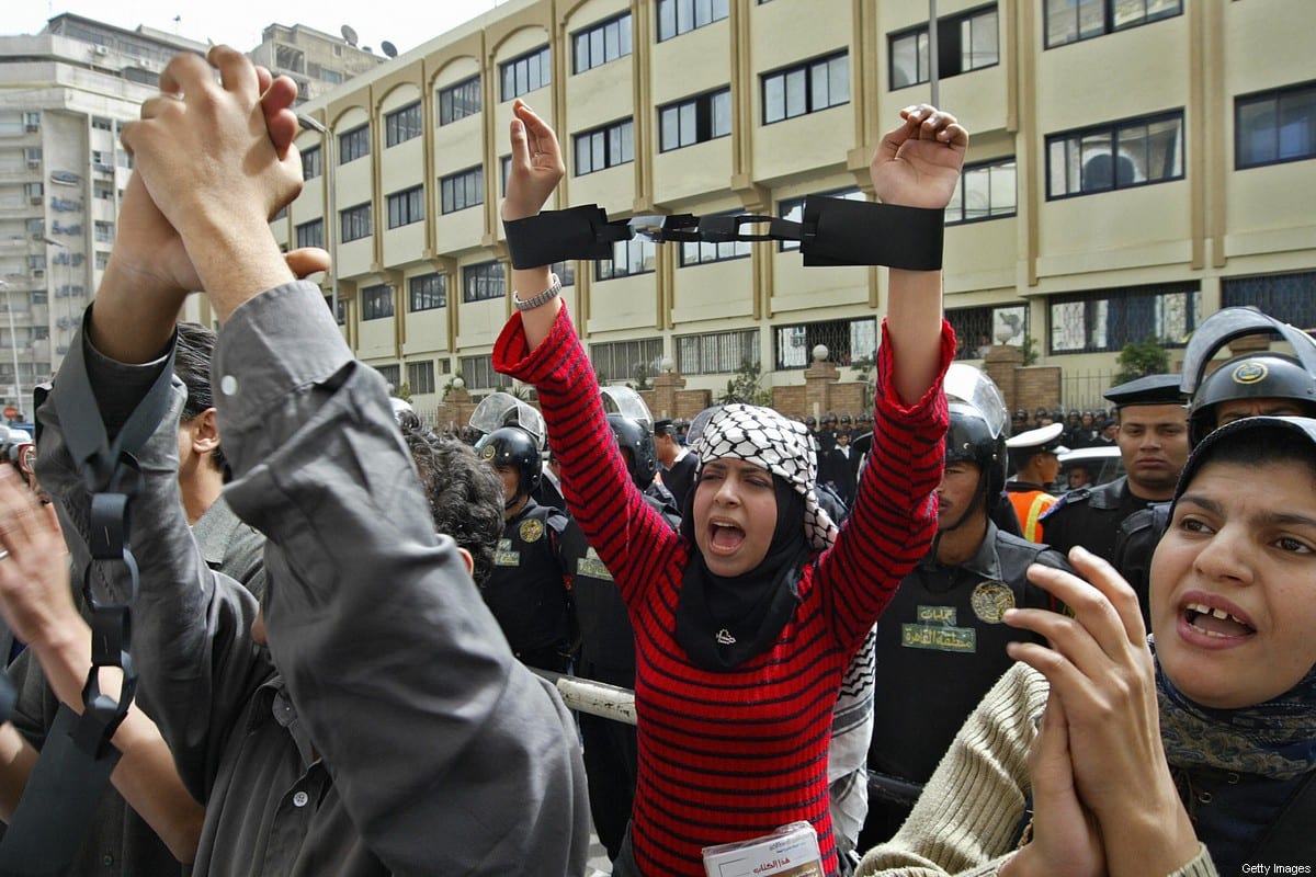 Ativista egípcia com algemas simbólicas em protesto contra o governo em frente ao sindicato da imprensa no centro do Cairo em 31 de março de 2005 [AFP via Getty Images]