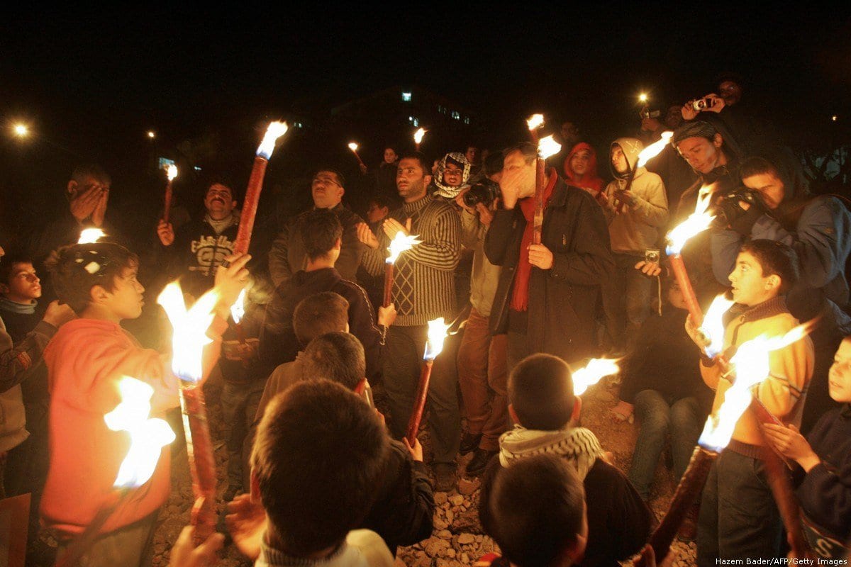 Parentes de palestinos mortos por um judeu extremista na Mesquita Ibrahimi de Hebron em 1994 fazem uma vigília de velas na cidade de Hebron, no sul da Cisjordânia, em 25 de fevereiro de 2009, para marcar o 15º aniversário desde que o fanático judeu Baruch Goldstein disparou contra fiéis, matando 29 pessoas e ferindo outras 150 antes de ser morto [Hazem Bader/AFP/Getty Images]