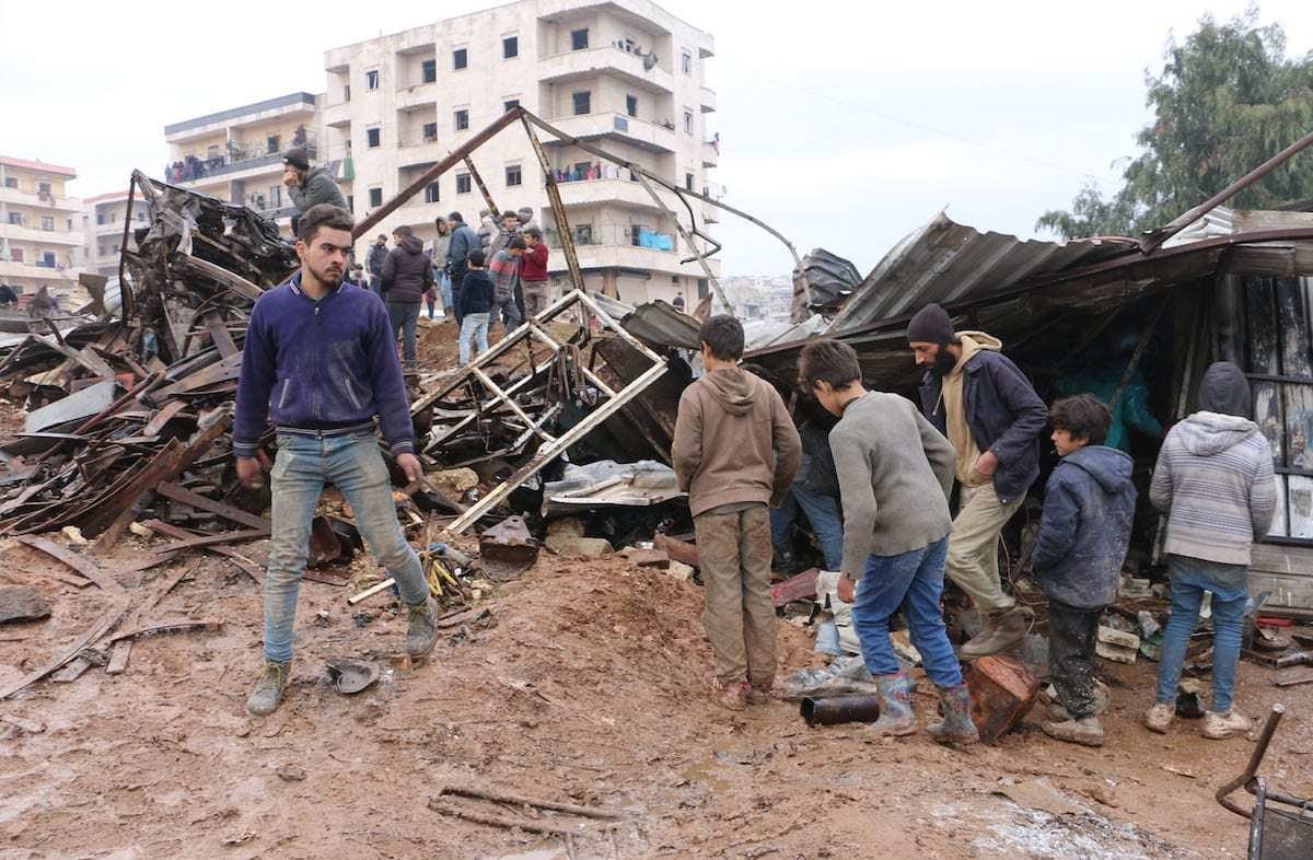 Pessoas inspecionam os escombros de um local destruído por um veículo carregado de explosivos, em Afrin, norte da Síria, 30 de janeiro de 2021 [Hisam El Homsi/Agência Anadolu]