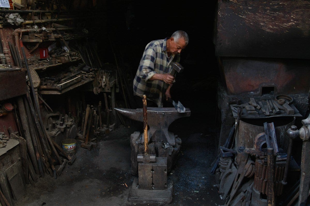 Um ferreiro egípcio martela em uma oficina de aço quente no Cairo, Egito. [David Silverman/Getty Images]
