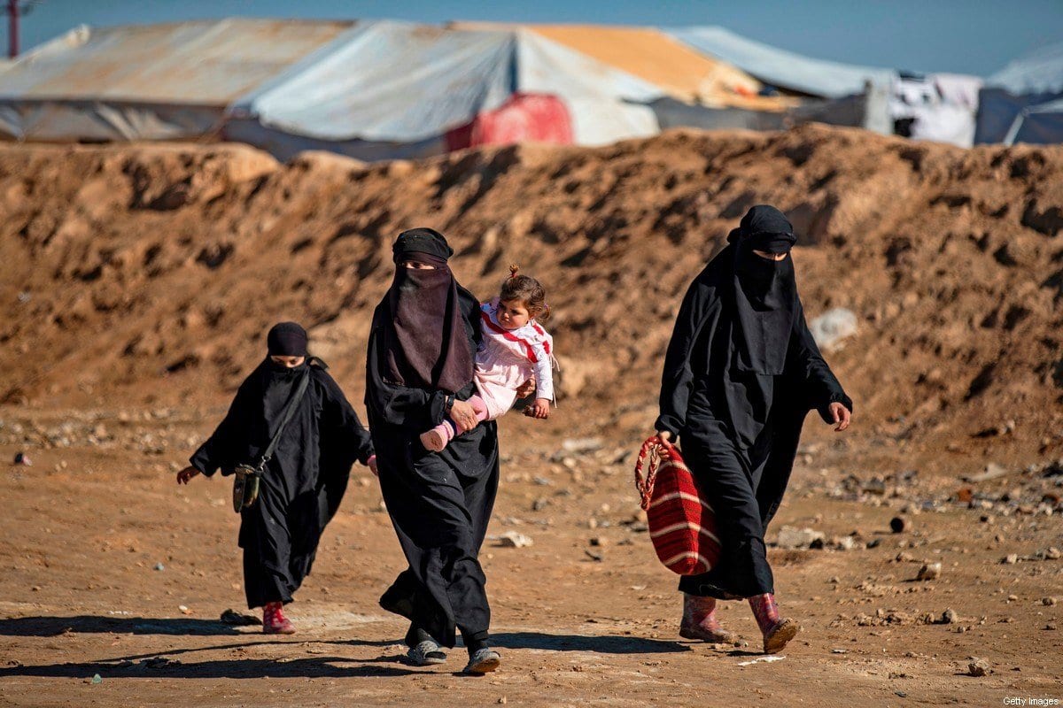 Mulheres e crianças passam por um acampamento onde famílias de combatentes estrangeiros do Daesh são mantidos na Síria em 14 de janeiro de 2020 [Delil Souleiman/ AFP / Getty Images]
