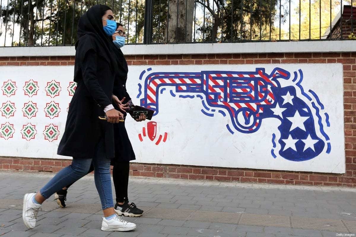 Mulheres iranianas passam em frente a um mural pintado na antiga embaixada dos Estados Unidos em Teerã, capital do Irã, em 4 de novembro de 2020, logo após as eleições presidenciais americanas [Atta Kenare/AFP/Getty Images]
