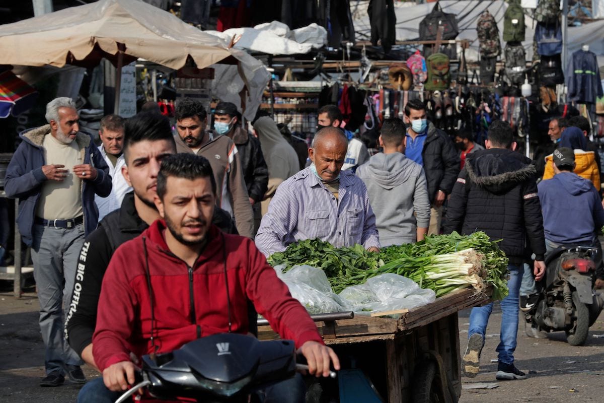 Libaneses, alguns usando máscaras de proteção devido à pandemia causada pela covid-19, fazem compras em um mercado no bairro de Sabra, em Beirute, em 6 de janeiro de 2021. [ANWAR AMRO/AFP via Getty Images]
