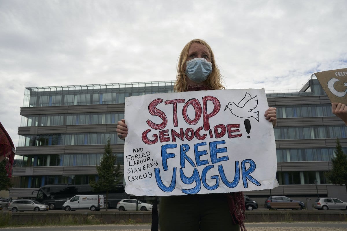 Manifestantes carregam cartazes com mensagens contra as políticas do governo chinês para o povo uigur, em 20 de agosto de 2020 em Haia, Holanda [Nacho Calonge / Getty Images]
