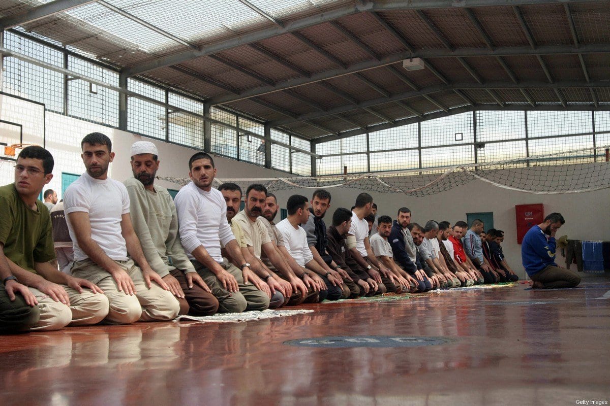 Prisioneiros palestinos oram em um ginásio, em 05 de março de 2006, na prisão Gilboa, a leste da cidade de Afula, no norte de Israel. [Hagai Aharon/AFP via Getty Images]
