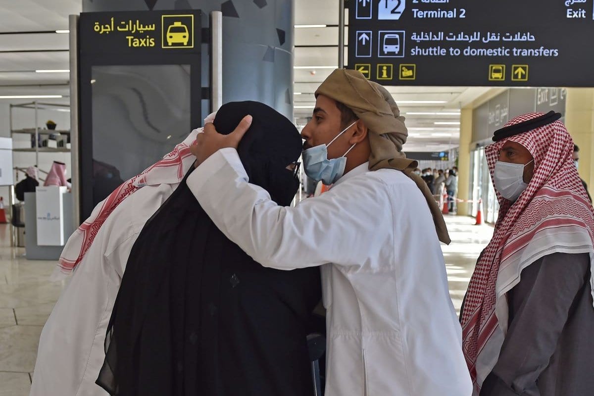 Homem abraça sua irmã que chegou ao Aeroporto Internacional King Khalid, na capital saudita, Riad, no primeiro vôo comercial do Catar, em 11 de janeiro de 2021 [Fayez Nureldine/ AFP via Getty Images] 
