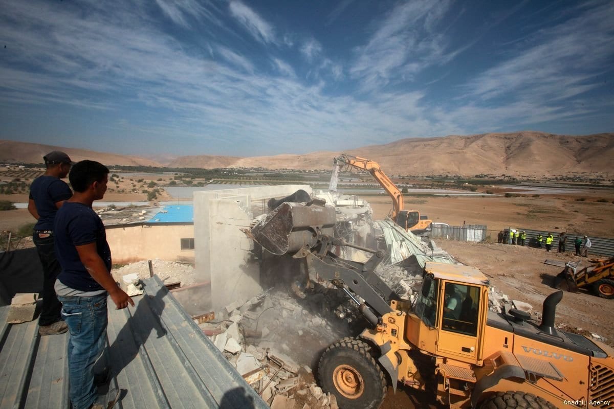 Palestinos assistem a demolição de sua casa por forças israelenses, na Cisjordânia ocupada, em 7 de novembro de 2017 [Nedal Eshtayah/Agência Anadolu]
