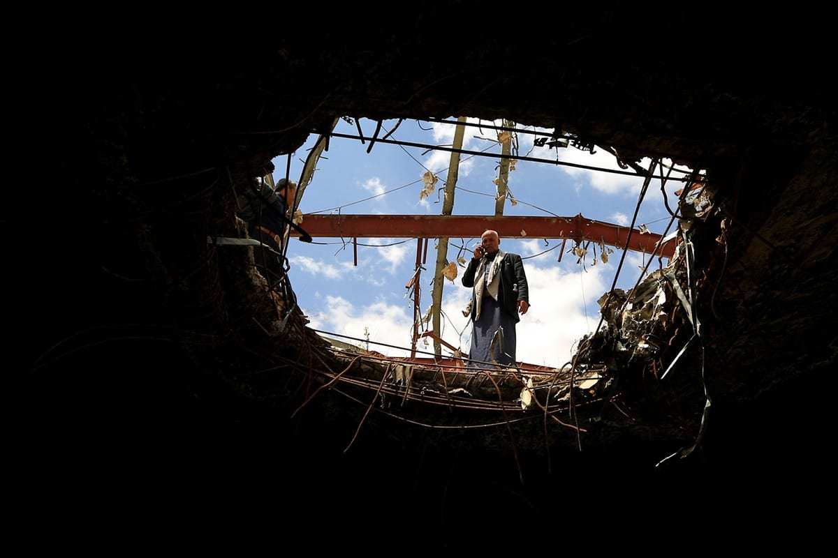 Iemenitas visitam o local de um prédio danificado após um ataque aéreo realizado pela Arábia Saudita no Iêmen, em 8 de outubro de 2019. [Mphammed Huwais/AFP/Getty Images]
